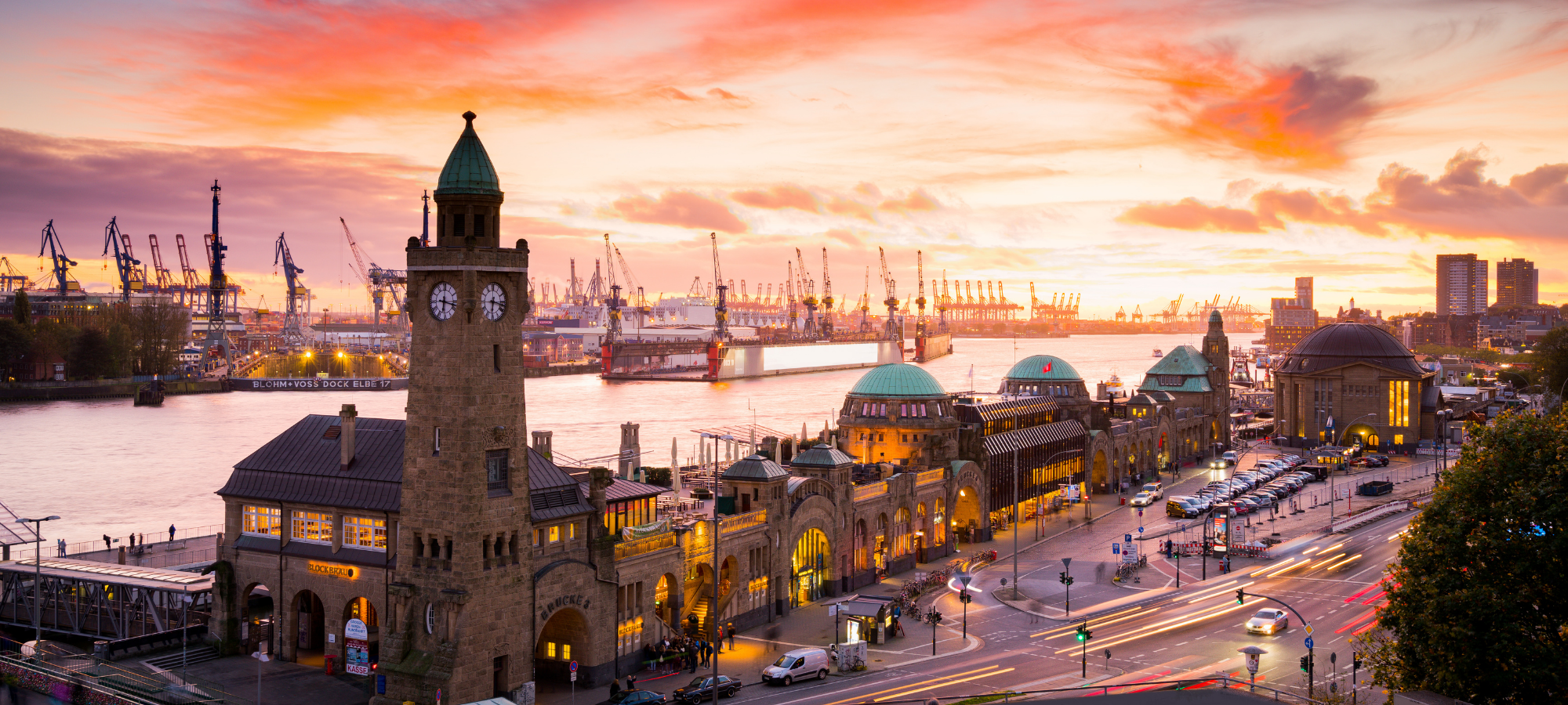 Hamburger Landungsbrücken bei Sonnenuntergang mit Hafen und Schiffen